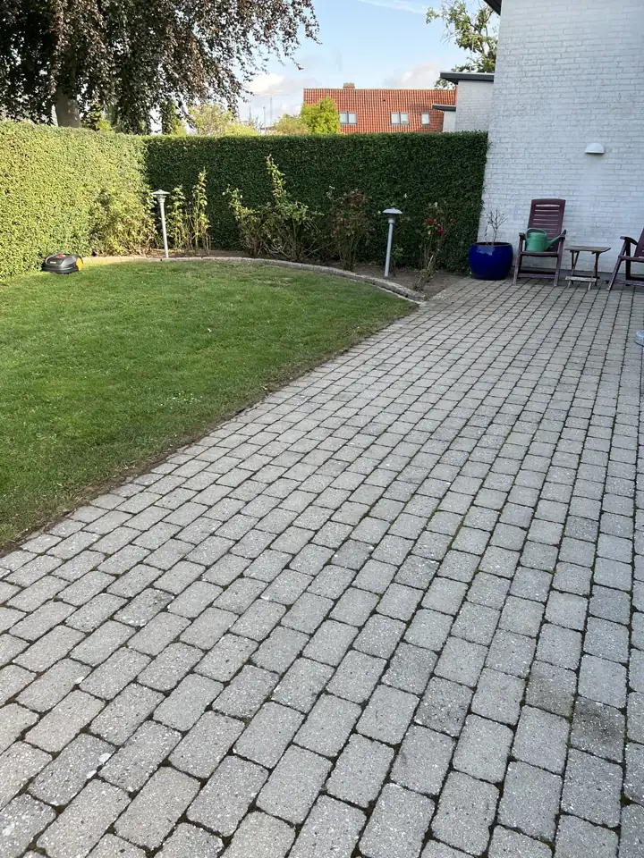 Flisegang uden ukrudt langs en græsplæne